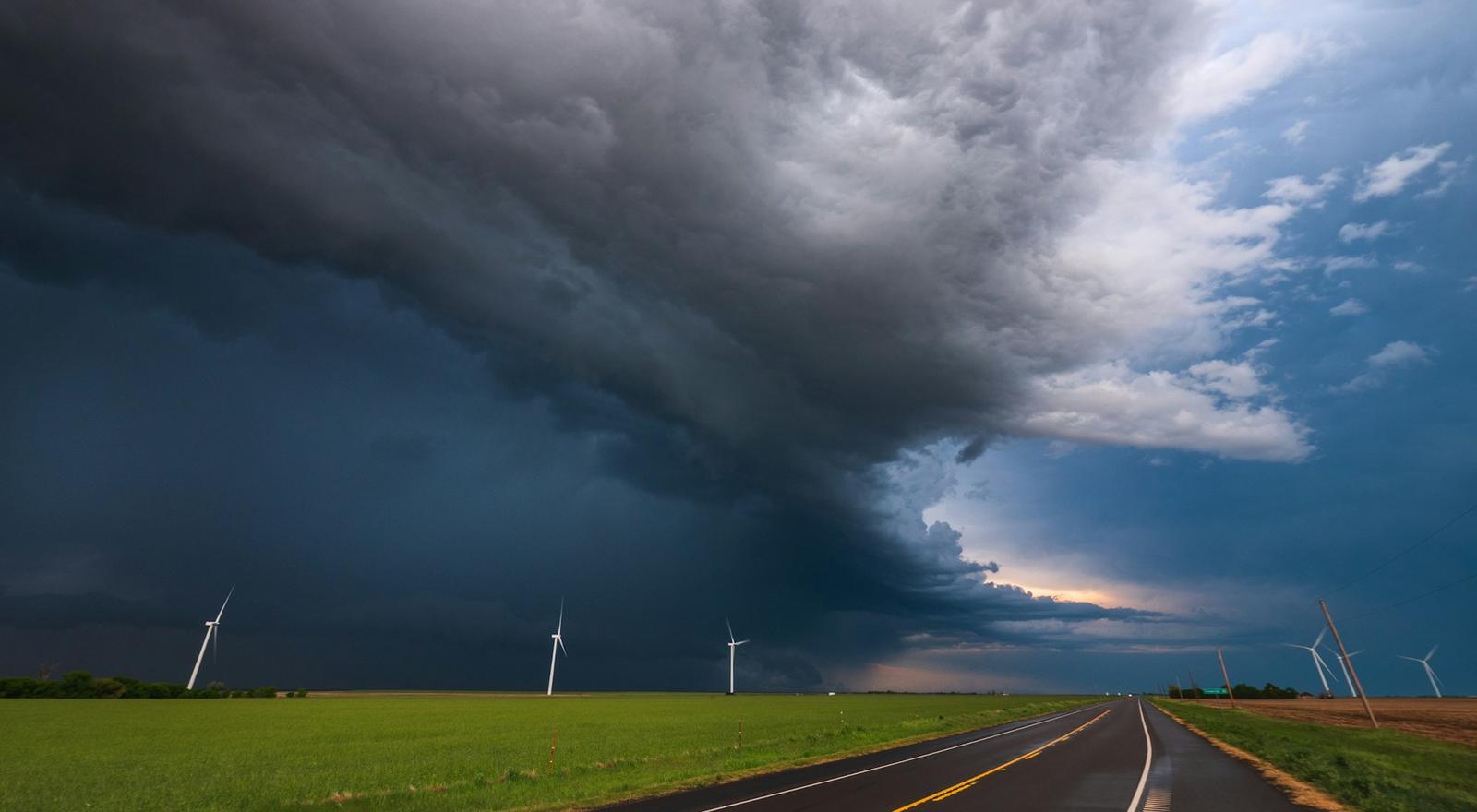 Two-lane highway through open Texas prairie under storm clouds