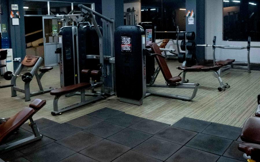 Strength machines and benches on a gym floor