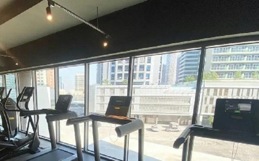 Row of commercial treadmills and an elliptical in a gym